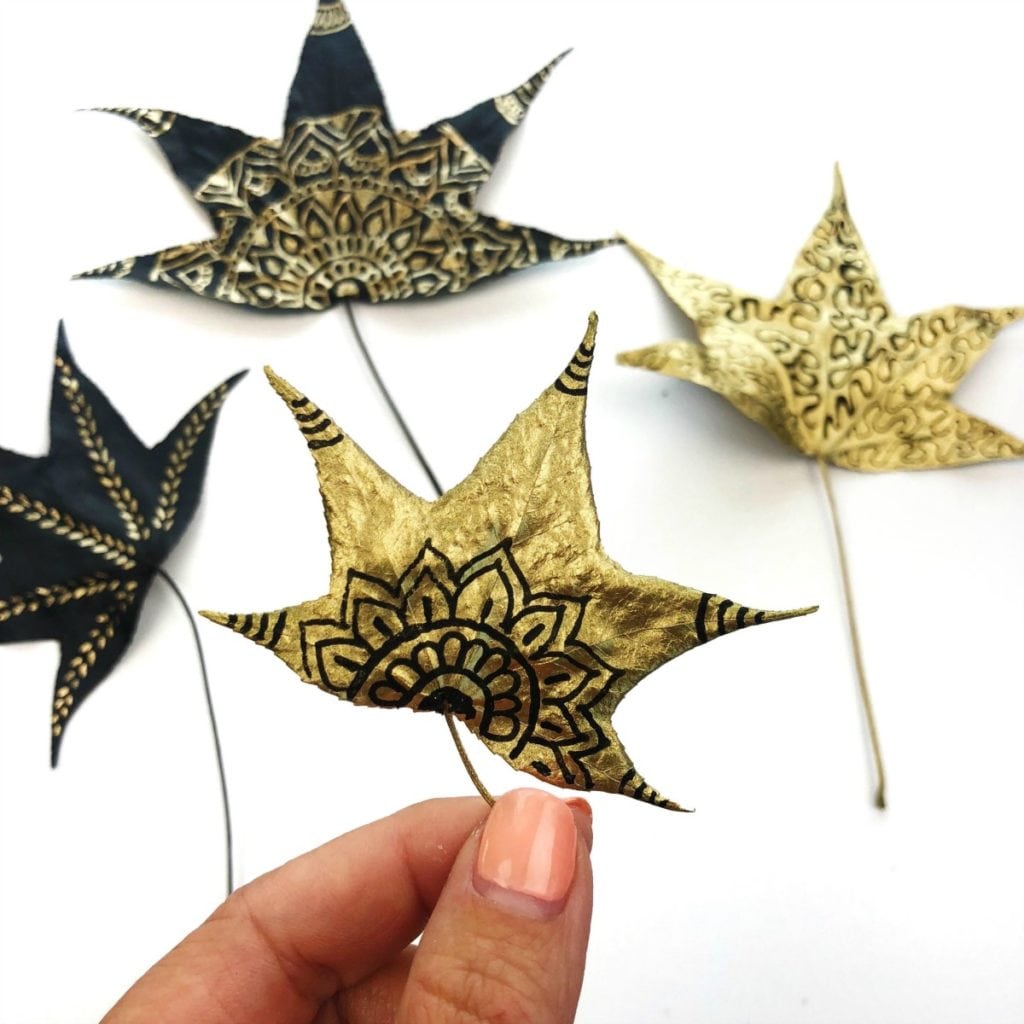 Metallic Leaf Art Doodles Example - a metallic gold leaf is in the foreground with black doodled designs