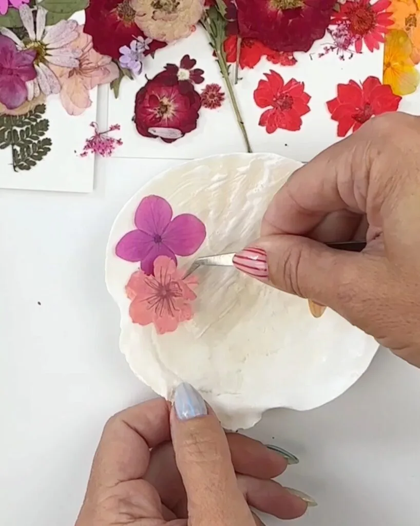 adding pressed flowers to shell